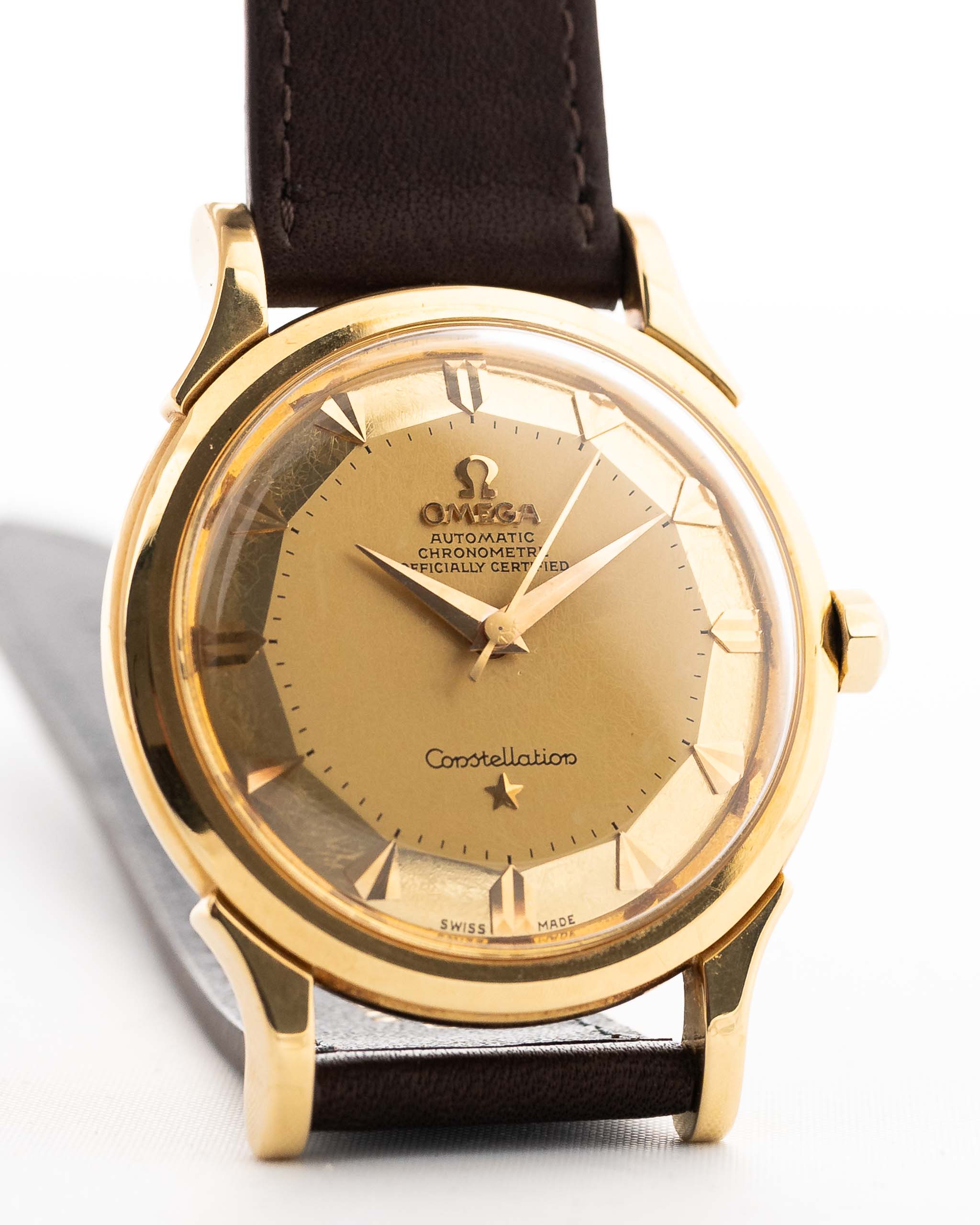 Closeup Photo of a Omega Constellation 2852 Pie Pan Arrow from 1956. 35mm case in Yellow Gold Case, Automatic Chronometer Caliber 505, Gold Pie Pan Dial, Brown Leather Strap.