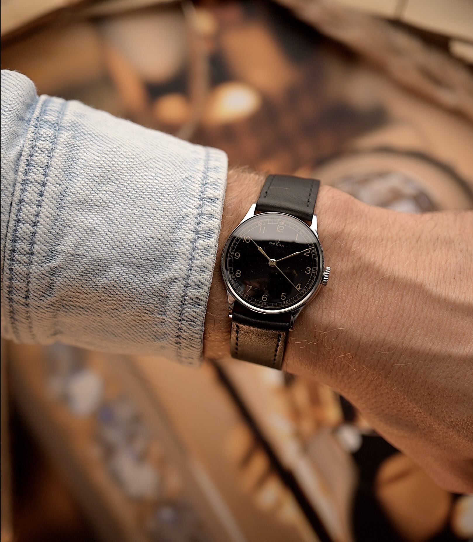 Vintage Omega watch Gilt Syringe from 1939, 33mm stainless steel case, black gilt dial, manual wind movement, black leather strap on wrist