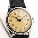 Closeup Photo of a Omega Radium Sword Arabic  from 1935 on a wrist. 28mm case in Stainless Steel with Manual wind movement, Original golden dial, Radium lume and Leather strap.