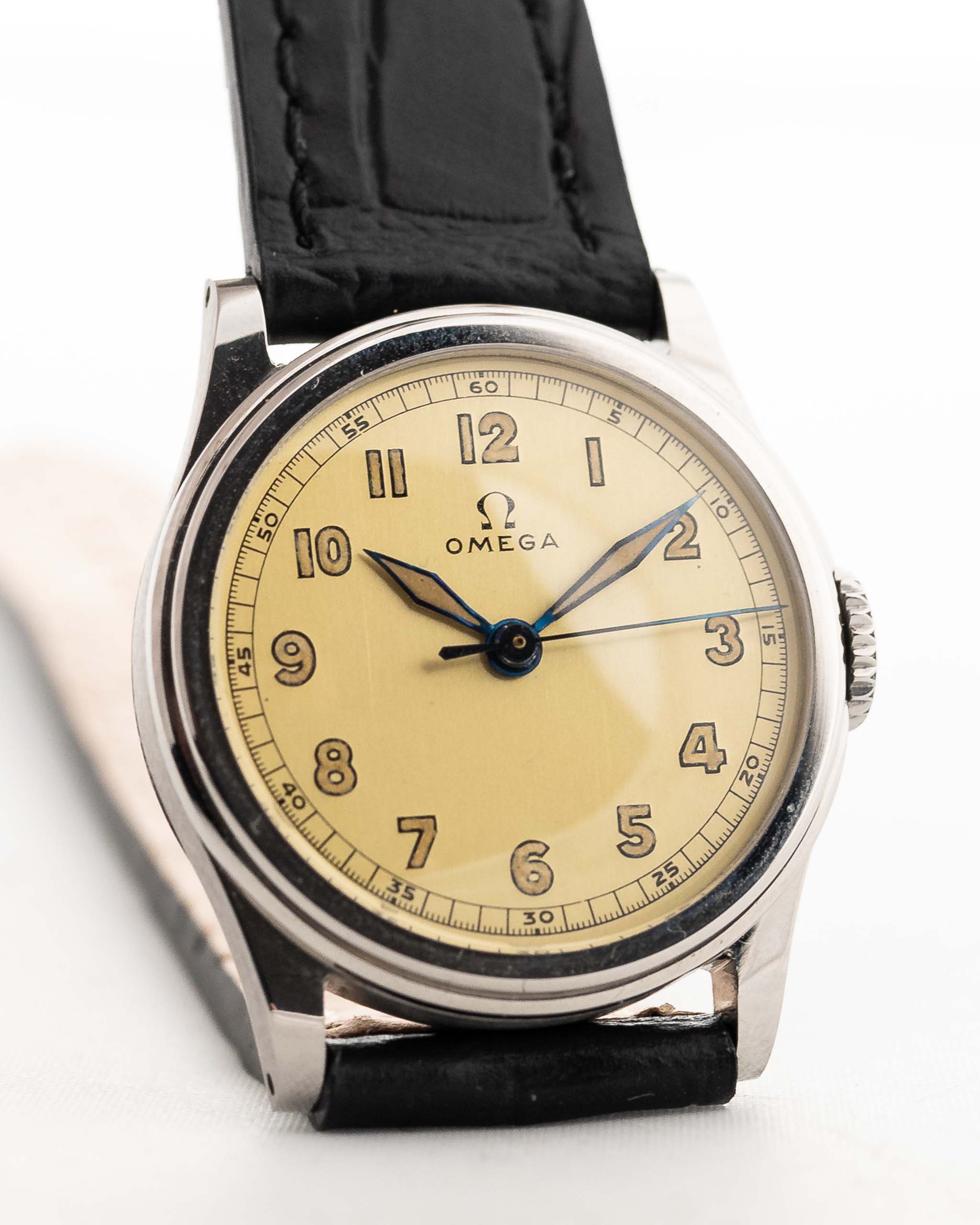 Closeup Photo of a Omega Radium Sword Arabic  from 1935 on a wrist. 28mm case in Stainless Steel with Manual wind movement, Original golden dial, Radium lume and Leather strap.