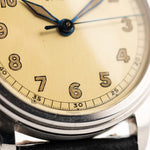 Closeup Photo of a Omega Radium Sword Arabic  from 1935 on a wrist. 28mm case in Stainless Steel with Manual wind movement, Original golden dial, Radium lume and Leather strap.