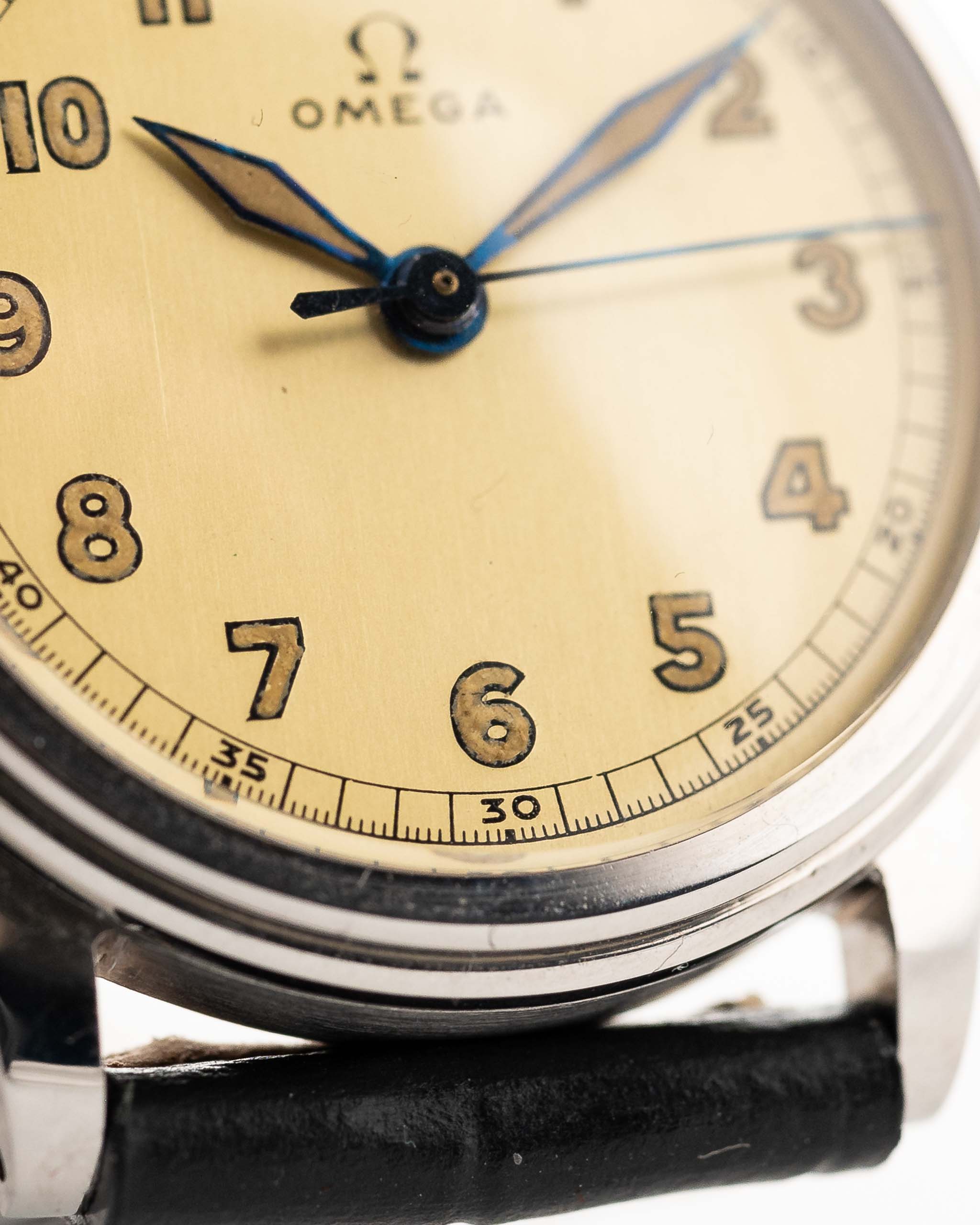 Closeup Photo of a Omega Radium Sword Arabic  from 1935 on a wrist. 28mm case in Stainless Steel with Manual wind movement, Original golden dial, Radium lume and Leather strap.