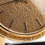 Closeup Photo of a Patek Philippe Calatrava 3569 Hammered 1970 on a wrist. 36mm case in 18k Yellow Gold Case wth Hammered Gold Dial, Automatic Movement and Original Leather Strap.
