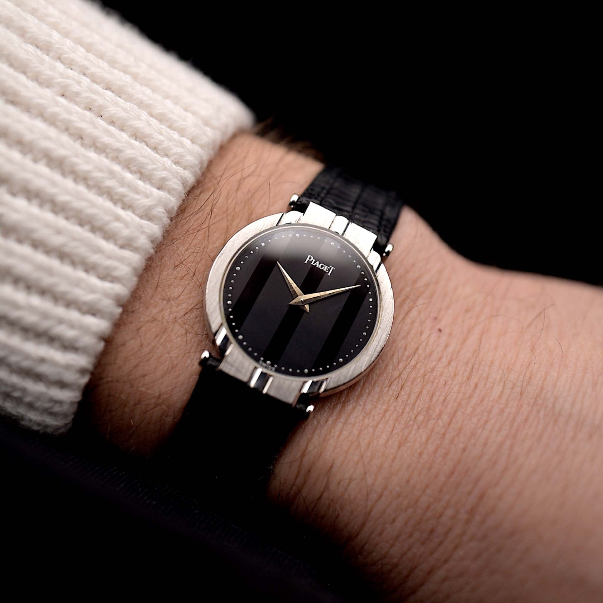 A photo of a vintage Piaget Polo 7273 from the 1980s. White gold case, 27.5mm, Piaget 7P Quartz movement with Original onyx dial and Leather strap.