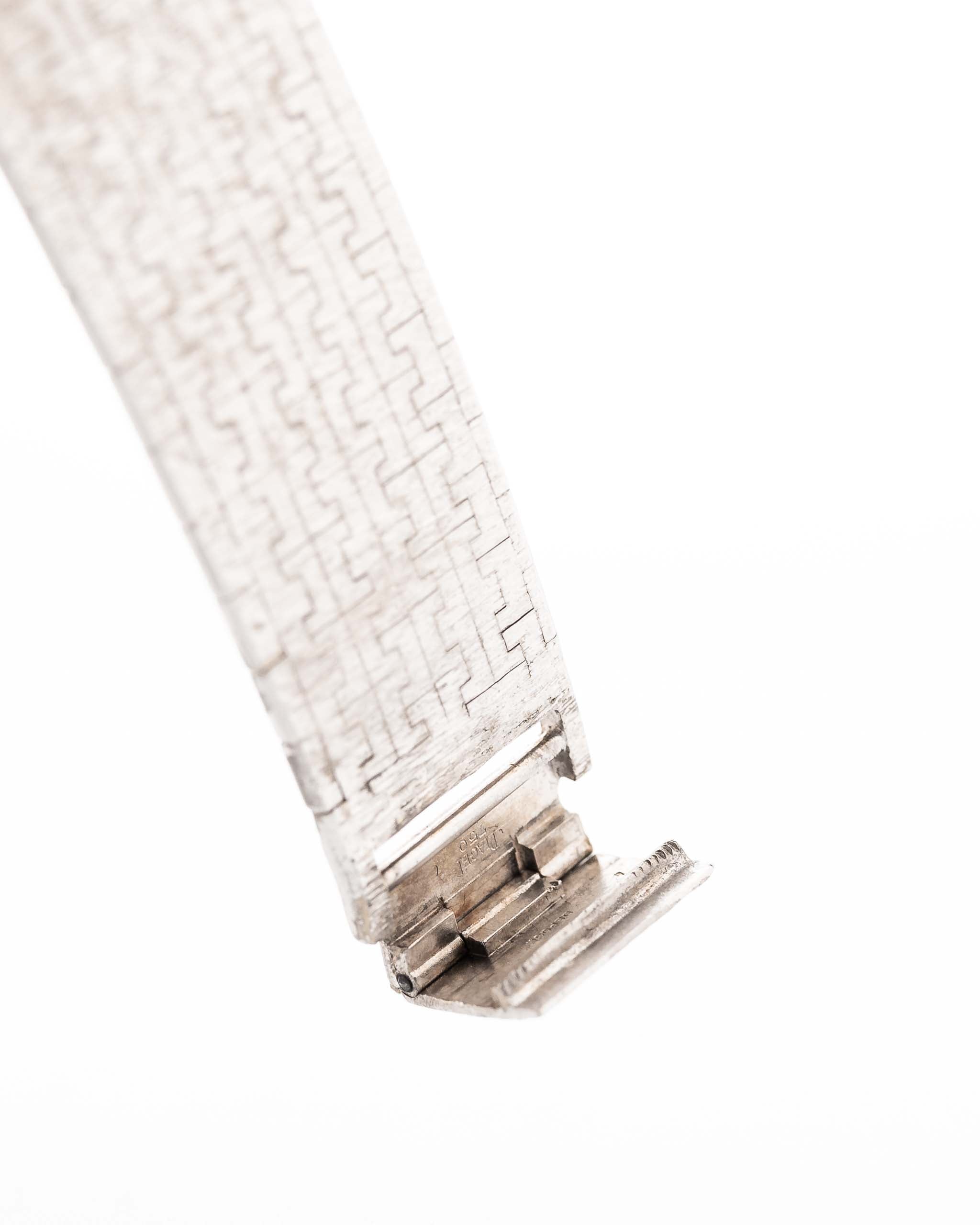 Closeup Photo of a Piaget 12401 Automatic 18k TV Bark from the 1970s on a wrist. 32.5mm with 18k White Gold Case, Automatic Movement, White Gold Hammered Dial and Integrated 18k.