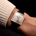 Photo of a Piaget Protocole 927 18k White Gold from the 1970s on a wrist. 25mm in 18k White Gold with Manual wind movement, Silver sunburst dial and Original black leather strap.
