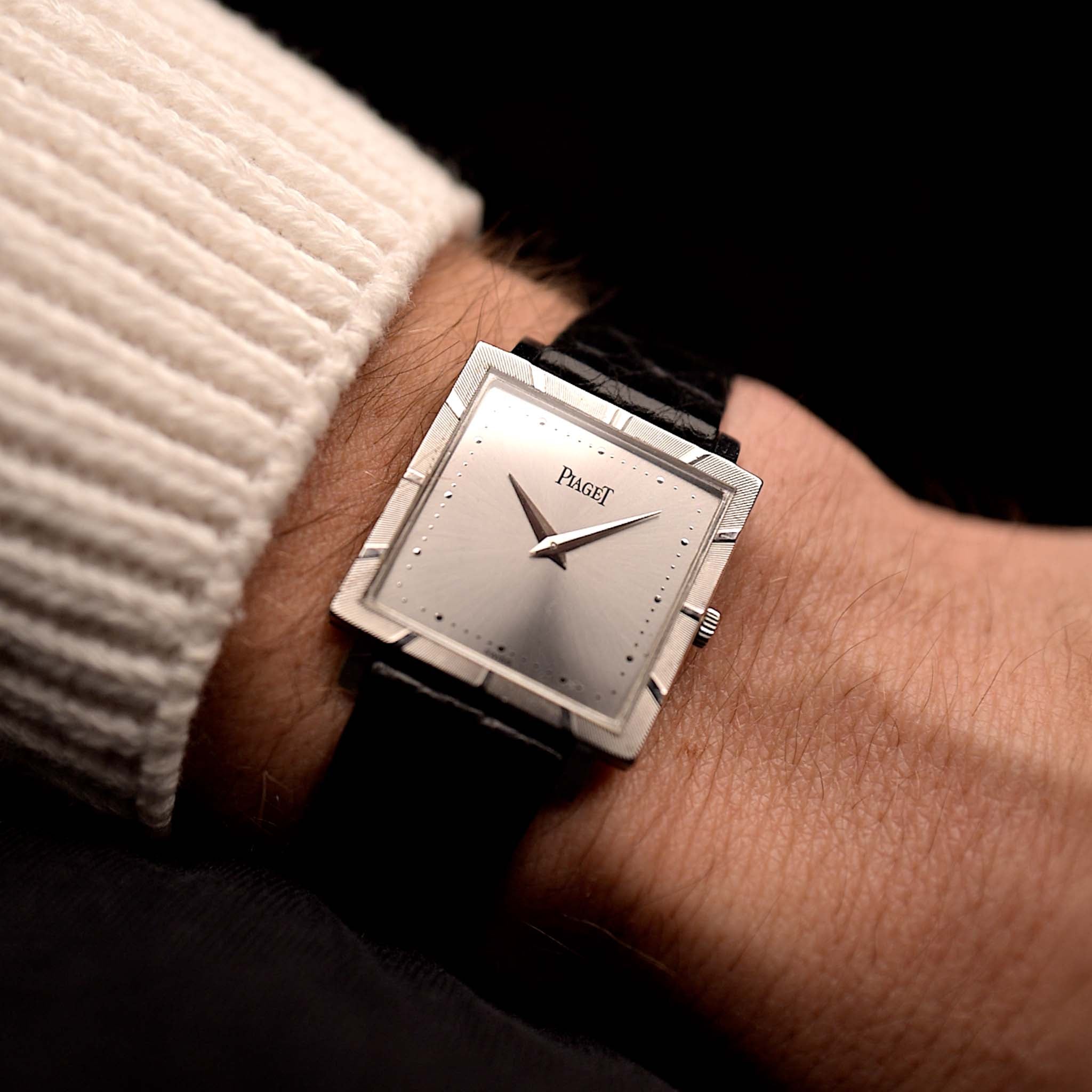 Photo of a Piaget Protocole 927 18k White Gold from the 1970s on a wrist. 25mm in 18k White Gold with Manual wind movement, Silver sunburst dial and Original black leather strap.