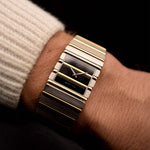 Gold Vintage Piaget Polo 7131 Onyx Zebra watch from the 1980s on a wrist with a dark background. 25mm wide, 18k white/yellow gold with Flawless Onyx and Zebra Dial, Gold bracelet.