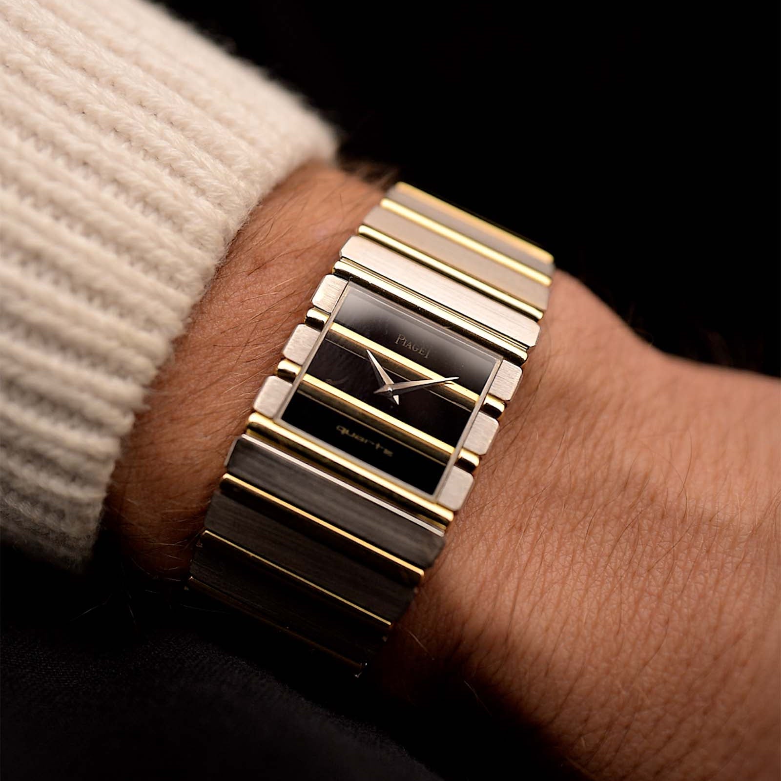 Gold Vintage Piaget Polo 7131 Onyx Zebra watch from the 1980s on a wrist with a dark background. 25mm wide, 18k white/yellow gold with Flawless Onyx and Zebra Dial, Gold bracelet.