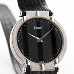 A closeup photo of a vintage Piaget Polo 7273 from the 1980s on a wrist. White gold case, 27.5mm, Piaget 7P Quartz movement with Original onyx dial and Leather strap.