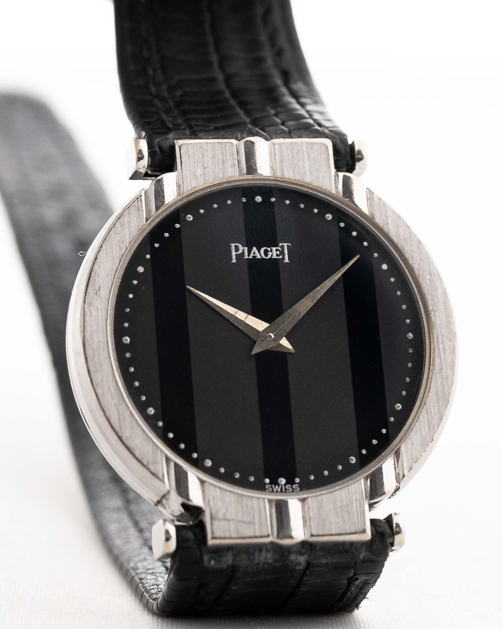 A closeup photo of a vintage Piaget Polo 7273 from the 1980s on a wrist. White gold case, 27.5mm, Piaget 7P Quartz movement with Original onyx dial and Leather strap.