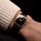 Photo of a Piaget Tonneau 9691 Onyx 18k from the 1970s on a wrist. 24mm with 18k Yellow Gold Case, Manual Wind Movement, Black Onyx Dial and Original black Leather Strap.