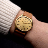 A photo of a vintage Rolex Cellini 3806 Ellipse 18k from 1974 on a wrist in Yellow gold. 32mm, Manual wind movement, Original golden dial and Original hands & crown with cognac brown Leather strap.