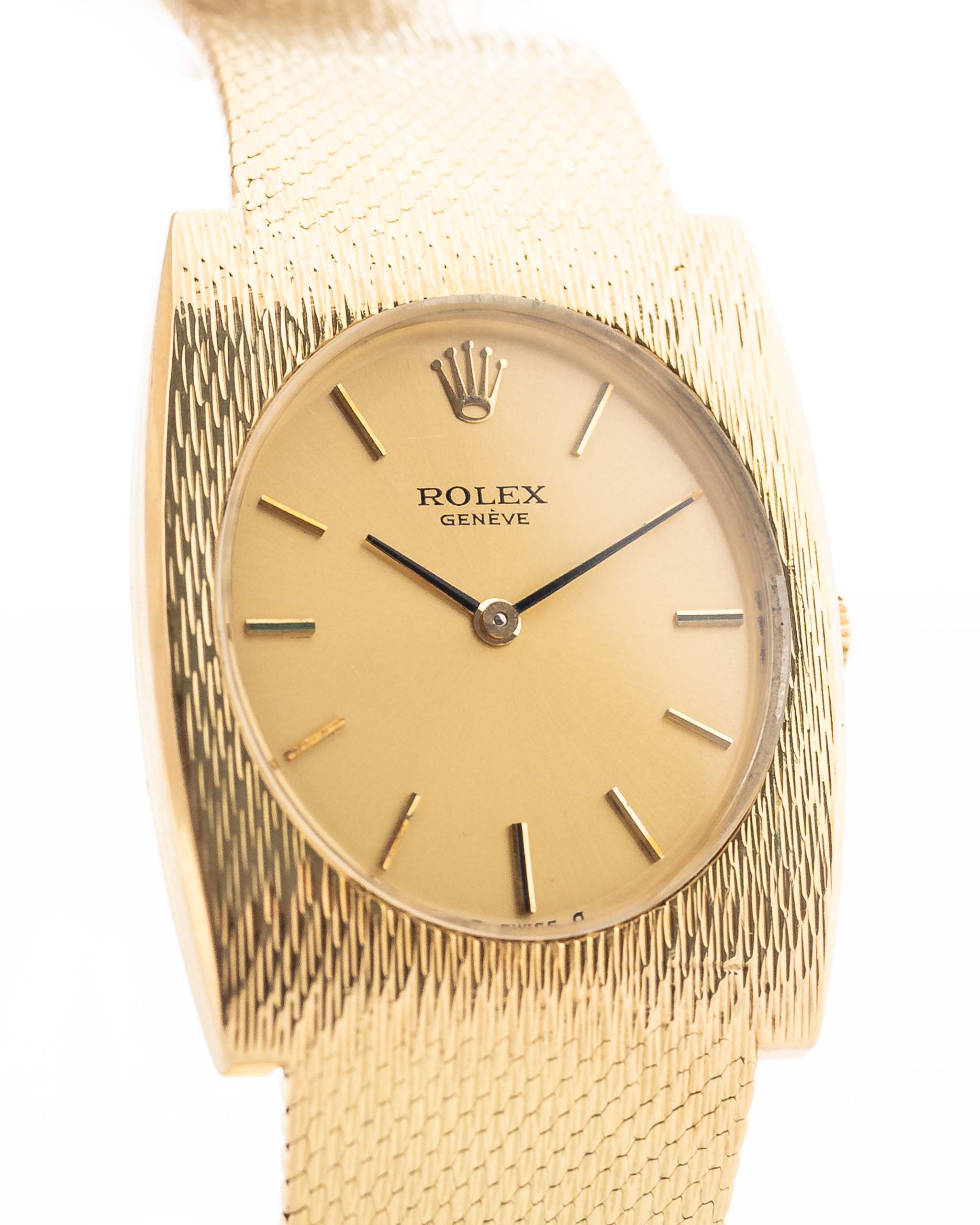 Closeup Photo of a vintage Rolex Geneve Rectangular from the 1960s on a wrist. In yellow gold, 28mm, Manual wind movement, Original golden sigma dial, and Original gold bracelet.