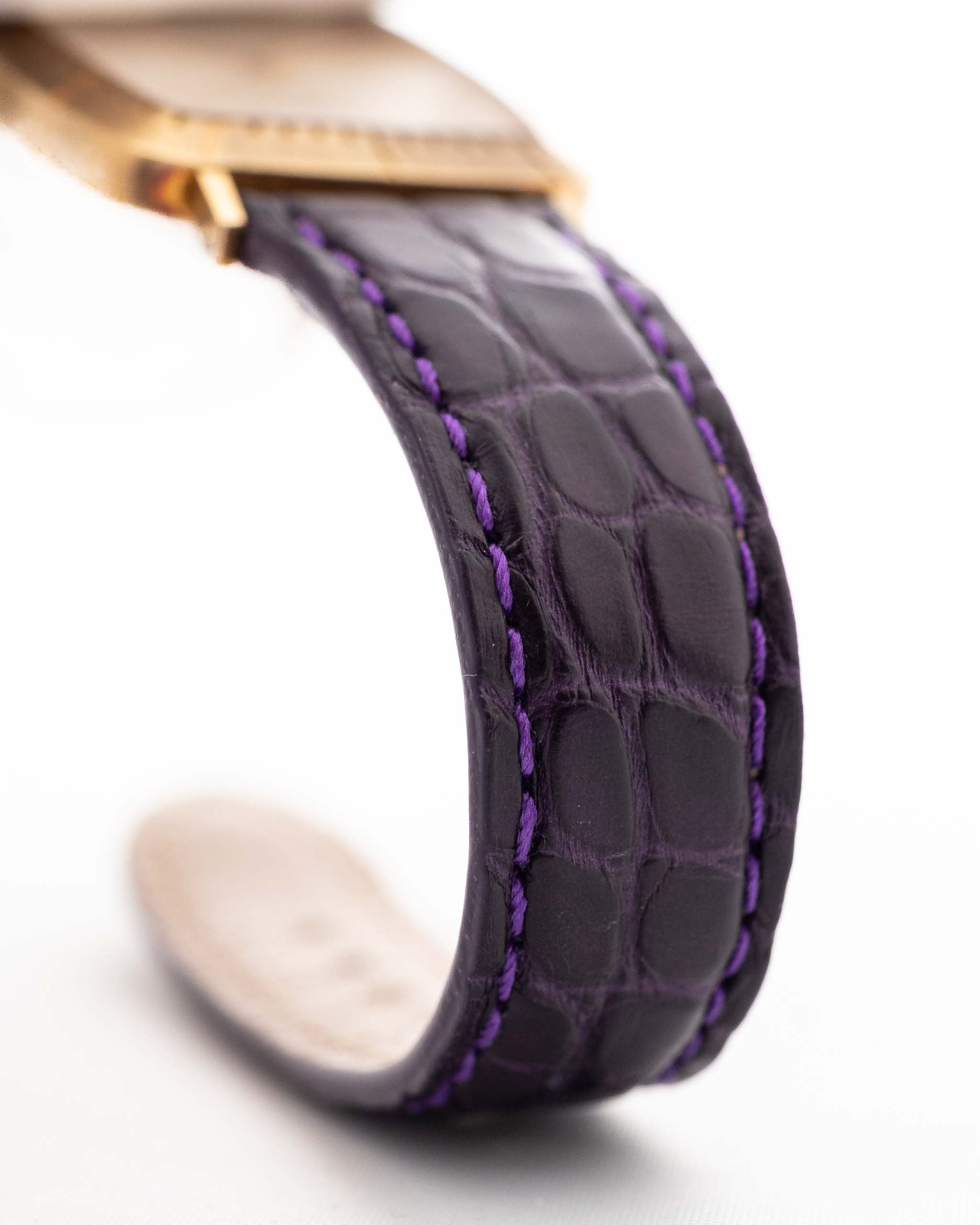 Closeup Photo of a Rolex Cellini 4087 Rectangular from 1995. 27.5mm in 18k Yellow Gold with Manual Wind Movement, Silver Sunburst Dial and Original Purple Leather Strap.