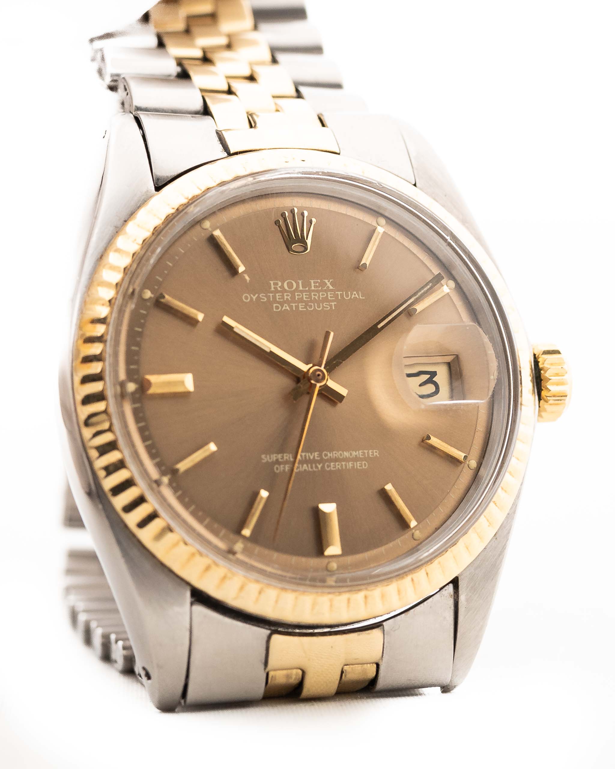 Close-up of a Vintage Rolex Datejust 1601 watch, brown Havana dial, stainless steel case, automatic movement, Two-tone Jubilee bracelet, white background