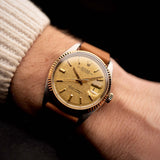 Vintage-Rolex-Datejust-Uhr aus dem Jahr 1972, zweifarbig, goldfarbenes Zifferblatt im „Pie-Pan“-Design, 36-mm-Oyster-Gehäuse, Automatikwerk, am Handgelenk vor schwarzem Hintergrund