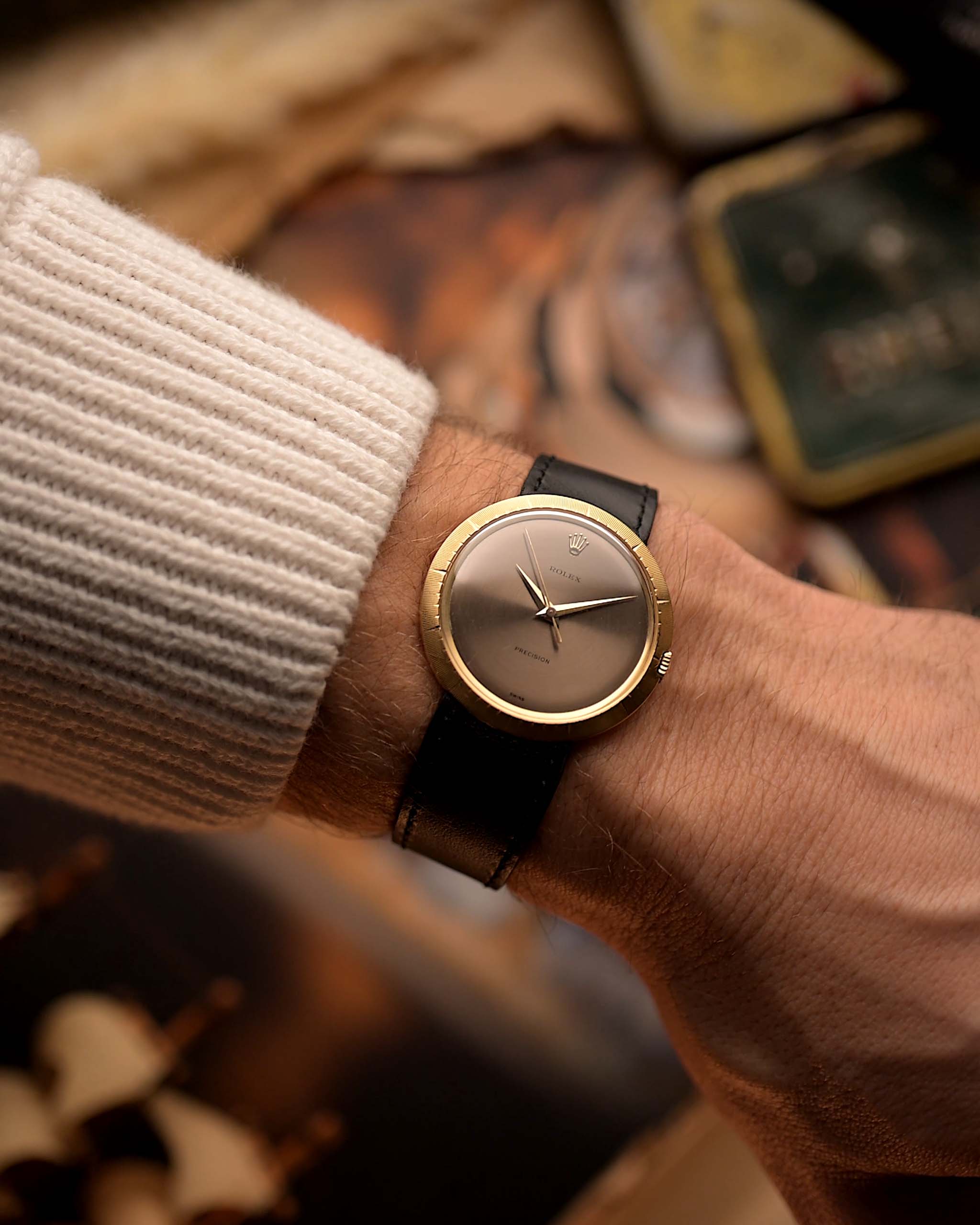 Vintage Rolex Precision 9919 watch, 18k gold, grey dial, Disco Volante case shape, on a wrist, blurred background