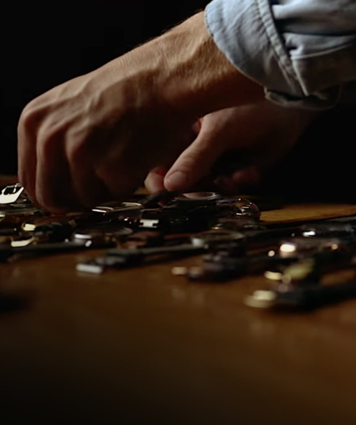 Close-up of hands working with vintage watches on a wooden surface