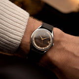 Universal Geneve Polerouter 204610, steel with tropical dial, worn on the wrist over a warm backdrop