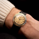 Vacheron Constantin 6395 Disco Volante Vintage watch from the 1960s, 18k gold, sunburst dial, manual movement, on a wrist on black background