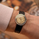 Vacheron Constantin 6395 Disco Volante Vintage watch from the 1960s, 18k gold, sunburst dial, manual movement, on a wrist on blurred background
