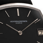 Close-up of a Vacheron Constantin watch face with black dial and silver accents.