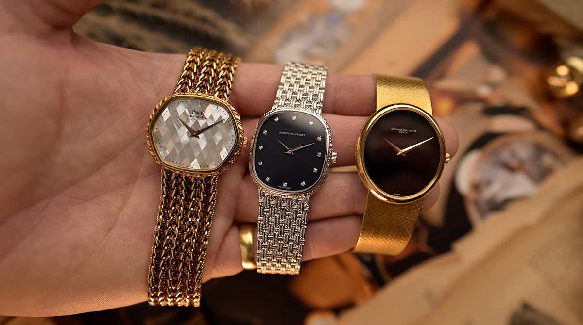 Three vintage dress watches resting across a hand.