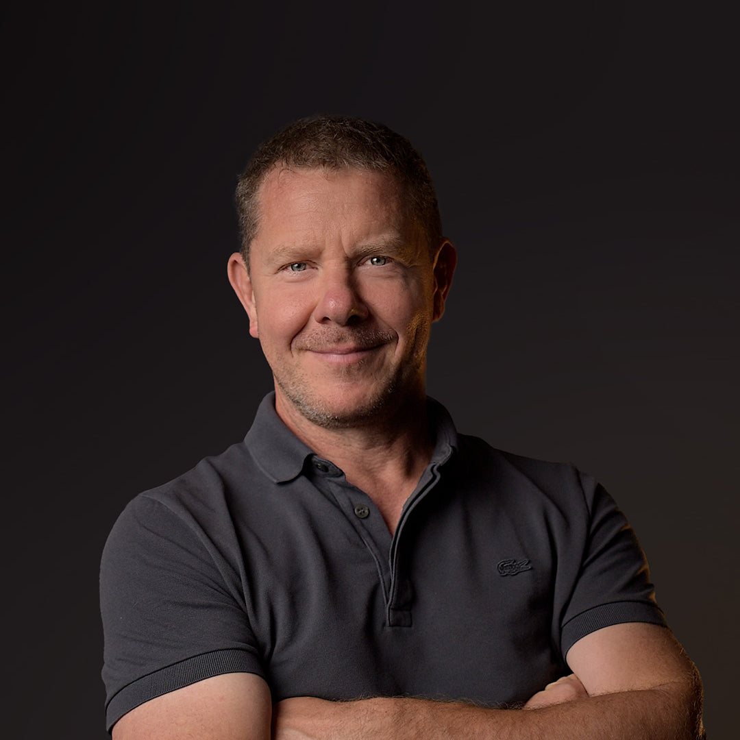 Man wearing a dark polo shirt against a black background
