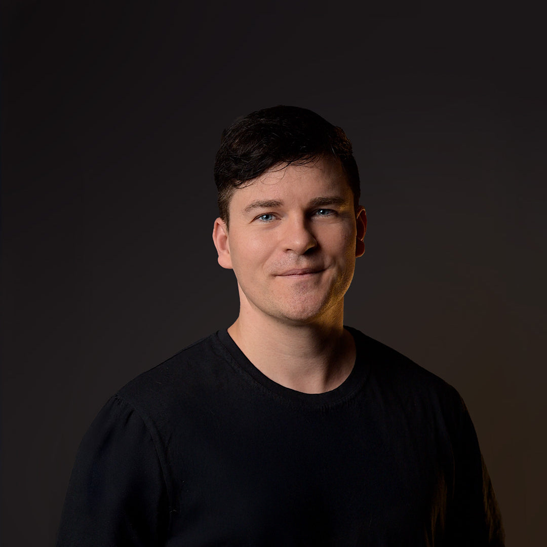 Man wearing a black shirt against a dark background