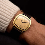 Vintage Piaget TV 12432 Automatic Watch 18k from the 1970s on a wrist. 32.5mm with 18k Yellow Gold Case, Automatic Caliber 12P1, Golden Dial, Leaf Hands and Leather Strap.