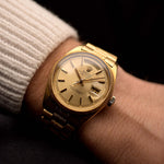 Vintage Rolex Day-Date 1811 watch, 18k yellow gold, golden dial, 36 mm Oyster case, Caliber 1556, on wrist, black background