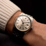 Vintage Rolex Datejust 1601 watch, silver sunburst dial, stainless steel case, automatic movement, Jubilee bracelet, on wrist, black background, video