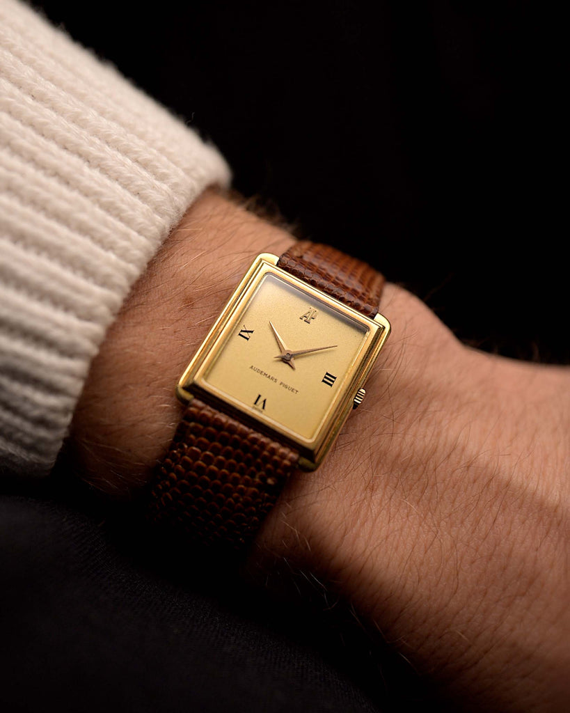 Vintage Audemars Piguet Square watch, 18k gold, golden satin dial, leather strap, on wrist, black background, video
