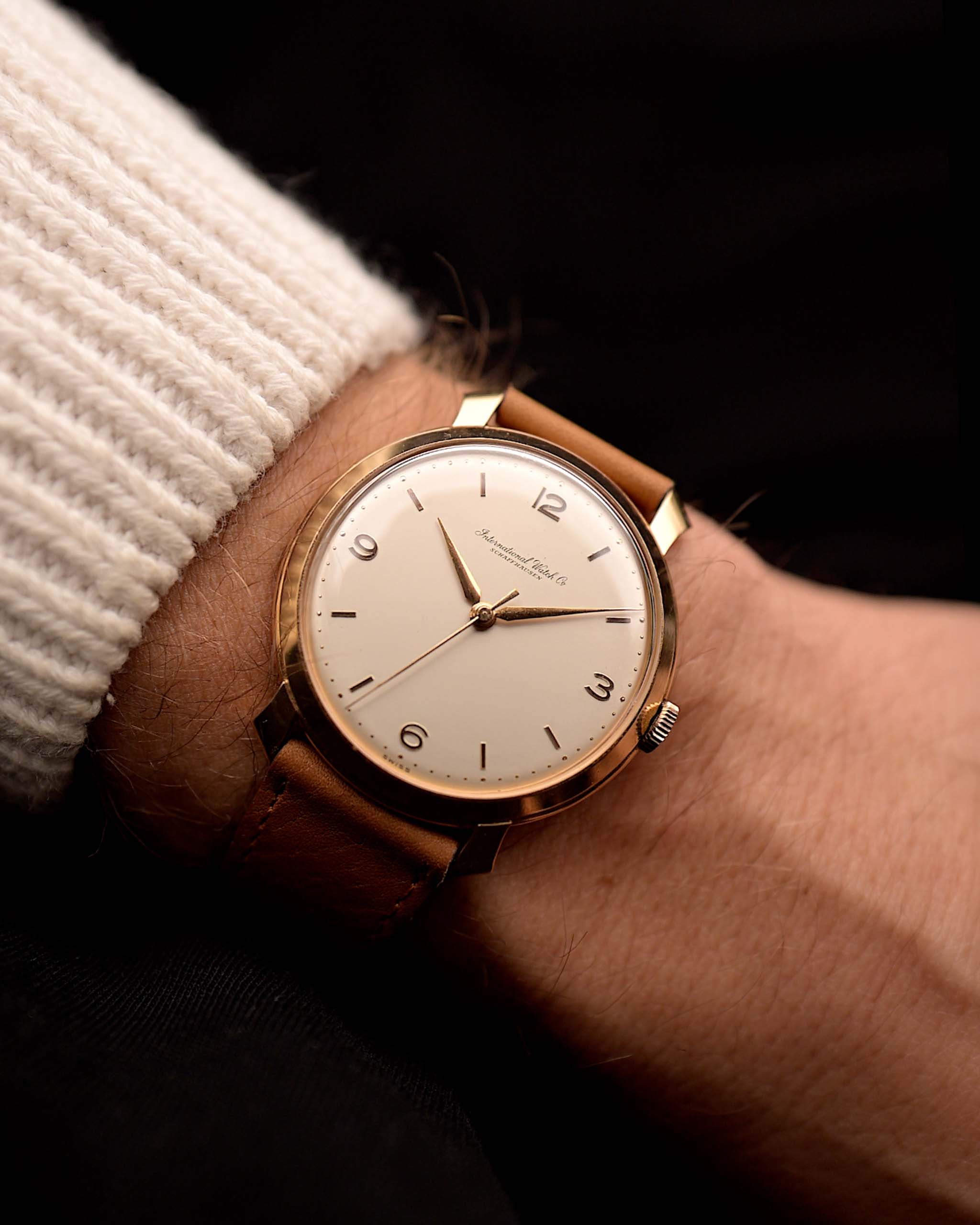 Vintage IWC Cal. 89 Shark Fin watch, in 18k rose gold, white silver dial, manual, brown leather strap on a wrist on black background, video