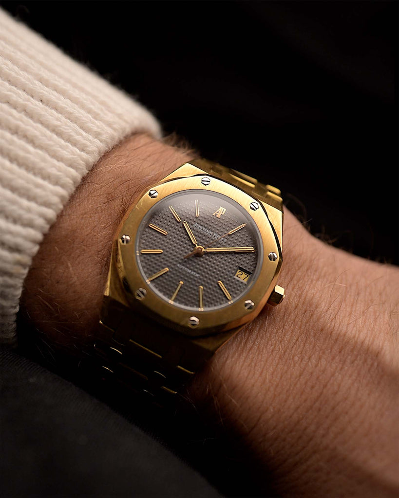 Vintage Audemars Piguet 4100BA Royal Oak watch from 1980 on a wrist. 35mm in 18k Yellow Gold with Automatic Caliber 2123, Flawless Grey Petit-Tapisserie Dial, Gold Bracelet and AP Extract.
