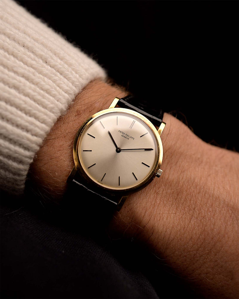 Vintage Patek Philippe 3520 Calatrava Watch 18k from the 1970s on a wrist. 32.5mm with 18k Yellow Gold Case, Manual Caliber 175, Flawless Silver Sunburst Dial and Original Leather Strap.