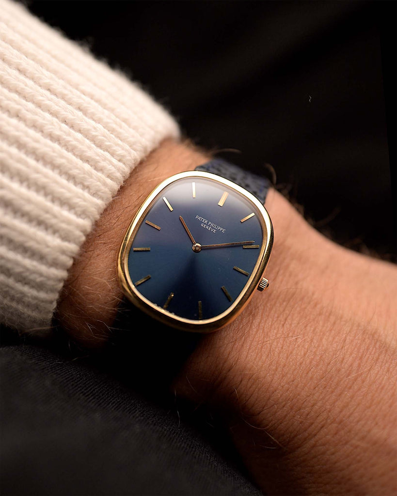 Vintage Patek Philippe 3738 Jumbo Ellipse Watch from the 1980s on a wrist. 31mm with 18k Yellow Gold Case, Automatic Caliber 240, Flawless MK1 Blue Sunburst Dial and Original Blue Leather Strap.