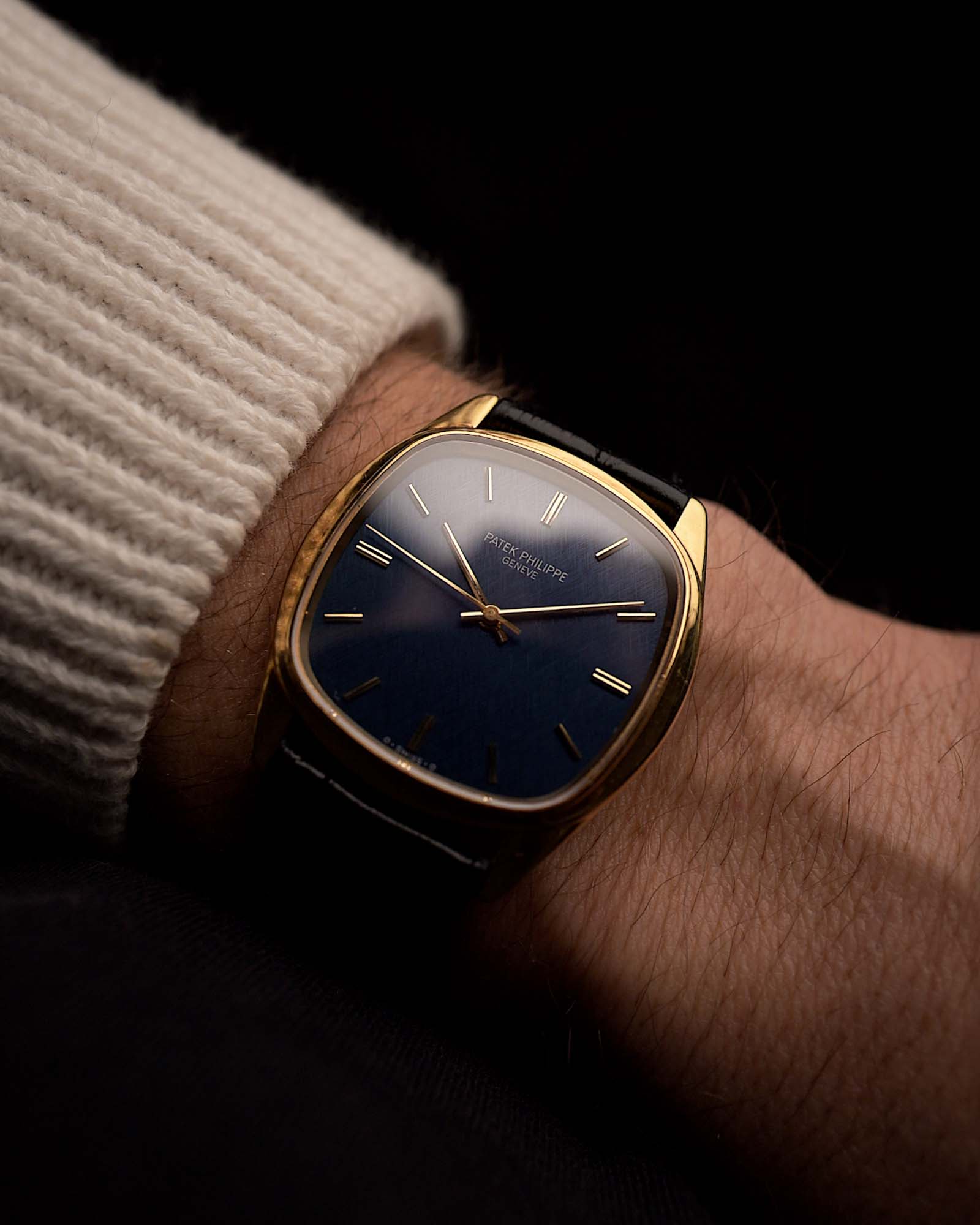 Vintage Patek Philippe 3585 watch in 18k gold, cushion case, blue dial, Cal. 350, black alligator strap on a wrist on black background, video