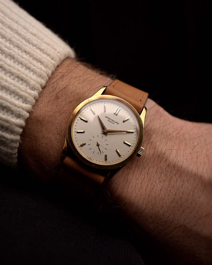 Vintage Patek Philippe 3796 watch from the 1980s, 31mm 18k yellow gold case, silver sigma dial, manual wind movement, on a wrist on black background, video