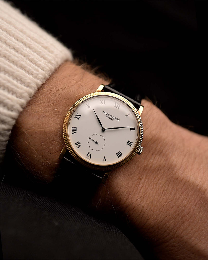 Vintage Patek Philippe Calatrava 3919 watch Sub Second Roman from the 1990s on a wrist. 33mm with 18k Yellow Gold Case, Manual Caliber 215, Flawless White Dial and Original Black Leather Strap.