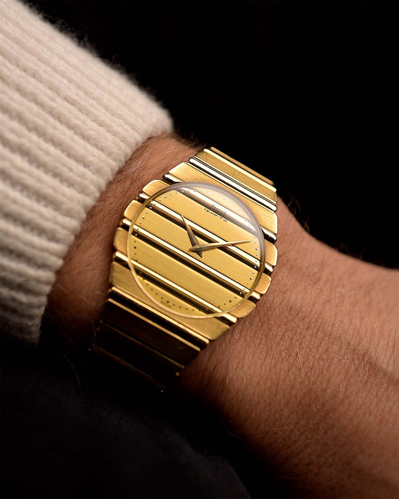 Gold Piaget Polo 7661 Jumbo 18k Watch on a person's wrist with a dark background. 34mm with 18k Yellow Gold Case, Quartz Movement, Flawless Gold Dial and Integrated Bracelet.