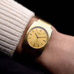 Video of a vintage Rolex Geneve Rectangular from the 1960s on a wrist. In yellow gold, 28mm, Manual wind movement, Original golden sigma dial, and Original gold bracelet.