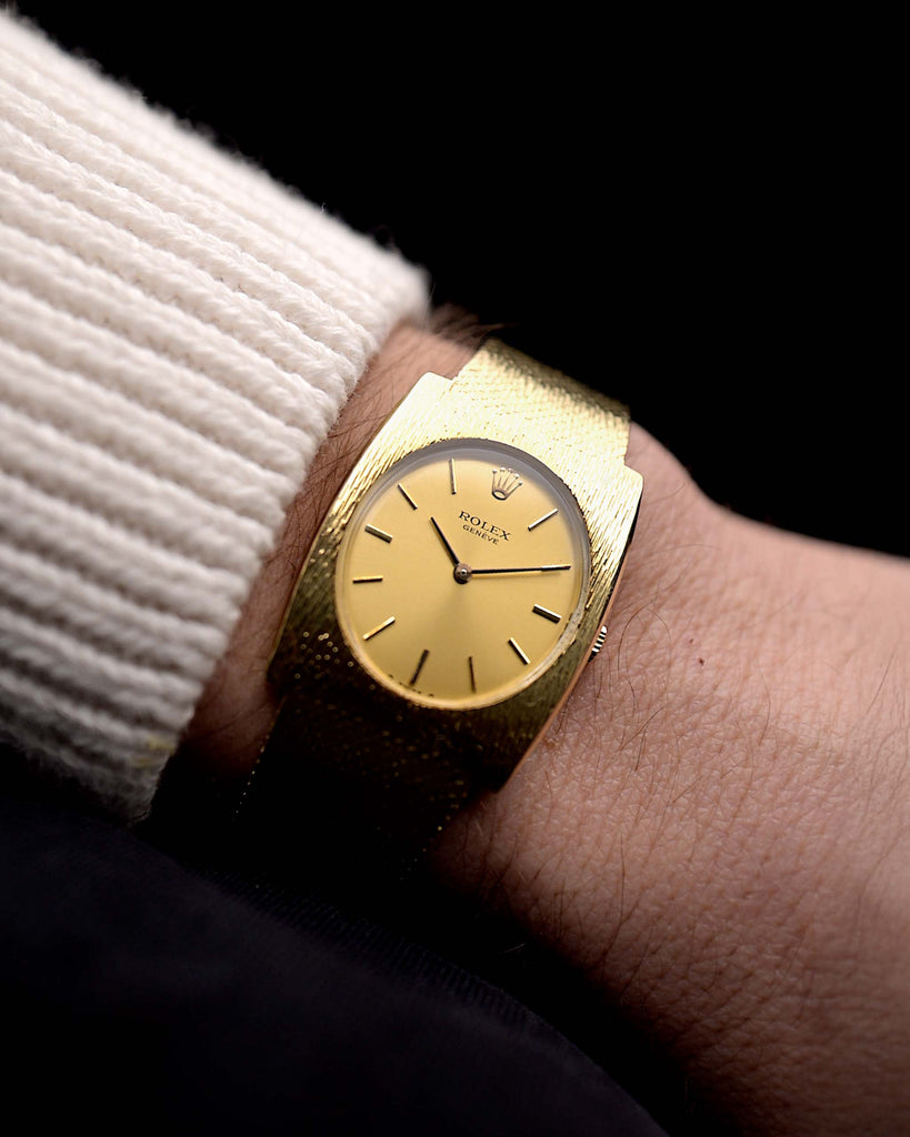 Video of a vintage Rolex Geneve Rectangular from the 1960s on a wrist. In yellow gold, 28mm, Manual wind movement, Original golden sigma dial, and Original gold bracelet.