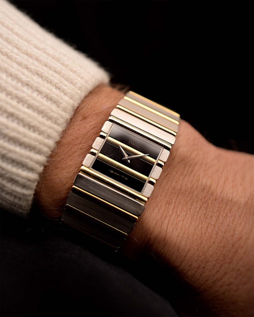 Gold Vintage Piaget Polo 7131 Onyx Zebra watch from the 1980s on a wrist with a dark background. 25mm wide, 18k white/yellow gold with Flawless Onyx and Zebra Dial, Gold bracelet.