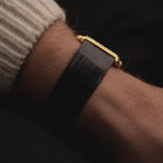 Vintage Piaget 74121 watch, 18k yellow gold, blue Hawk's Eye dial, rectangular case, quartz movement, on black background