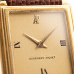 Nahaufnahme einer Vintage Audemars Piguet Square Uhr, 18k Gold, goldenes satiniertes Zifferblatt, Lederband, weißer Hintergrund