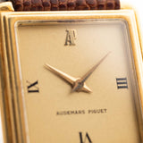 Nahaufnahme einer Vintage Audemars Piguet Square Uhr, 18k Gold, goldenes satiniertes Zifferblatt, Lederband, weißer Hintergrund