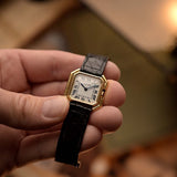 Vintage Cartier Ceinture 78210 Uhr in 18k Gelbgold, weißes MK3 Zifferblatt, Handaufzug, in der Hand gehalten, unscharfer Hintergrund