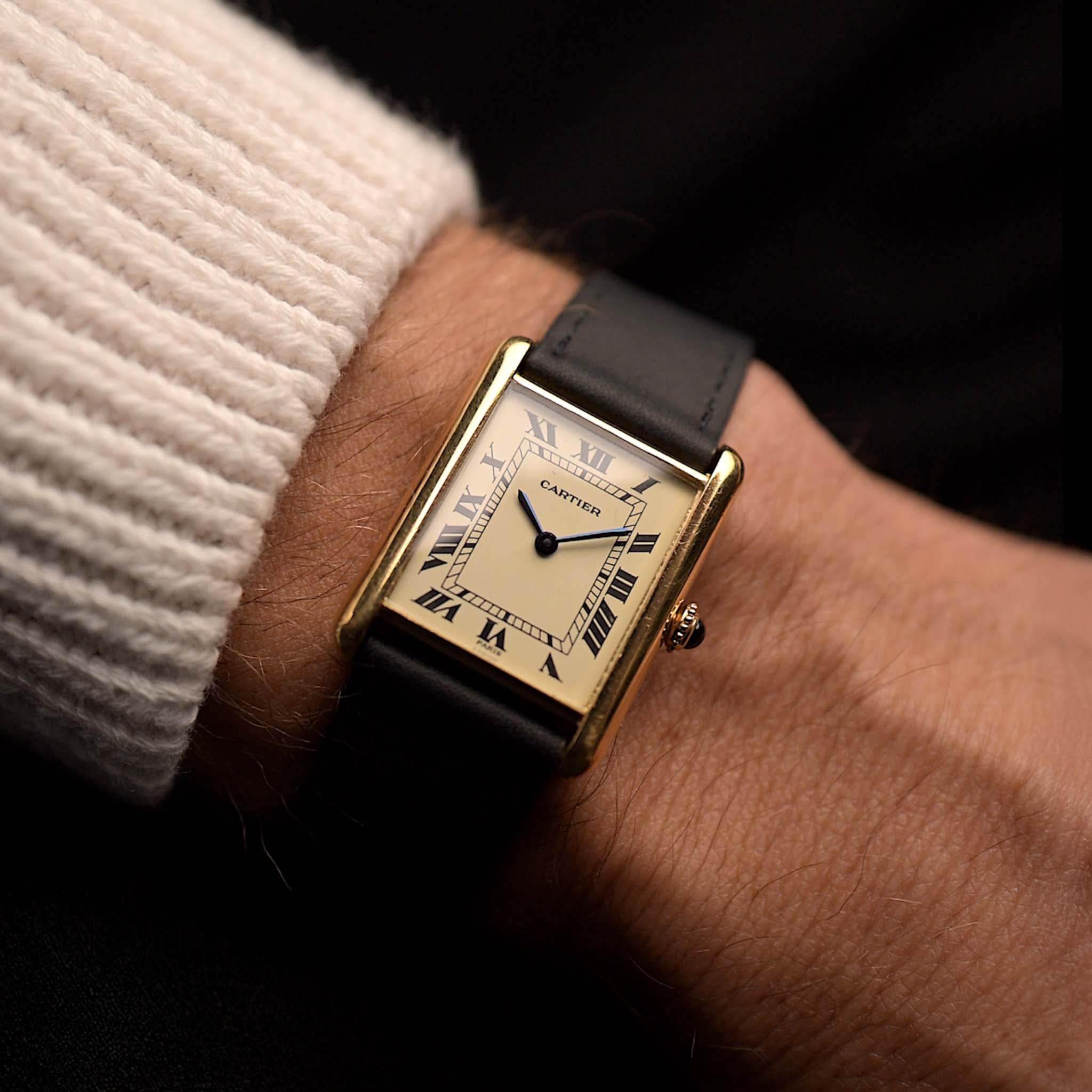 Vintage Cartier Tank Louis 78086 Paris aus den 1970er Jahren an einem Handgelenk. 23x30mm mit Gehäuse aus 18k Gelbgold, Uhrwerk mit Handaufzug, makellosem elfenbeinfarbenem Zifferblatt, Zeigern und Lederarmband.